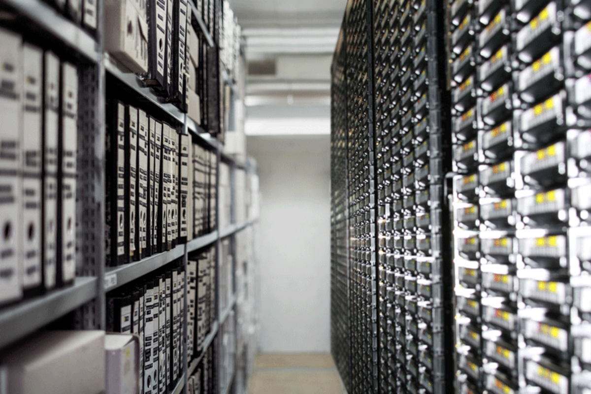 Foto eines Regales mit Aktenordnern und einem Teil der Archivbänder
