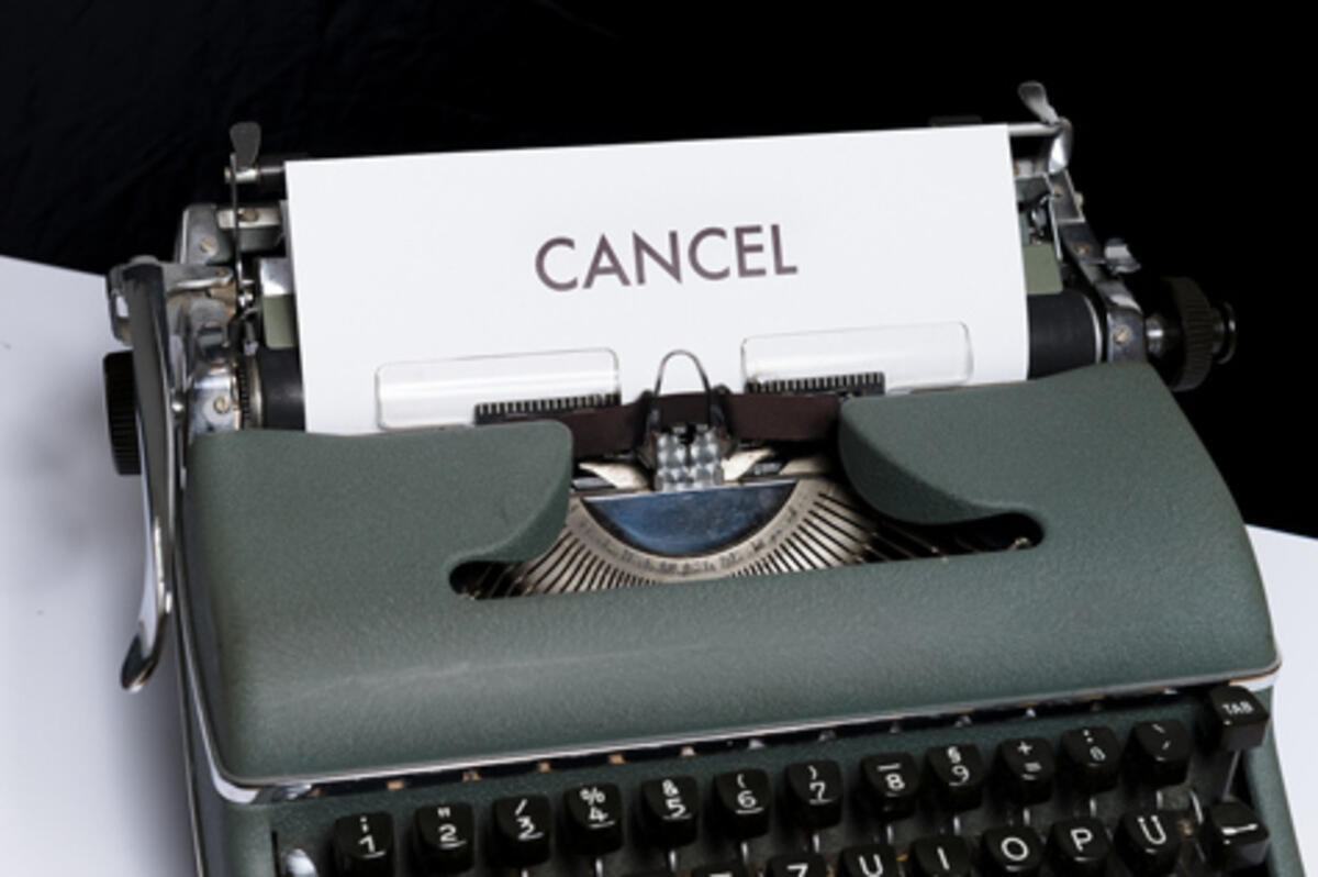 Photo of an old typewriter with a sheet of paper with cancel written on it