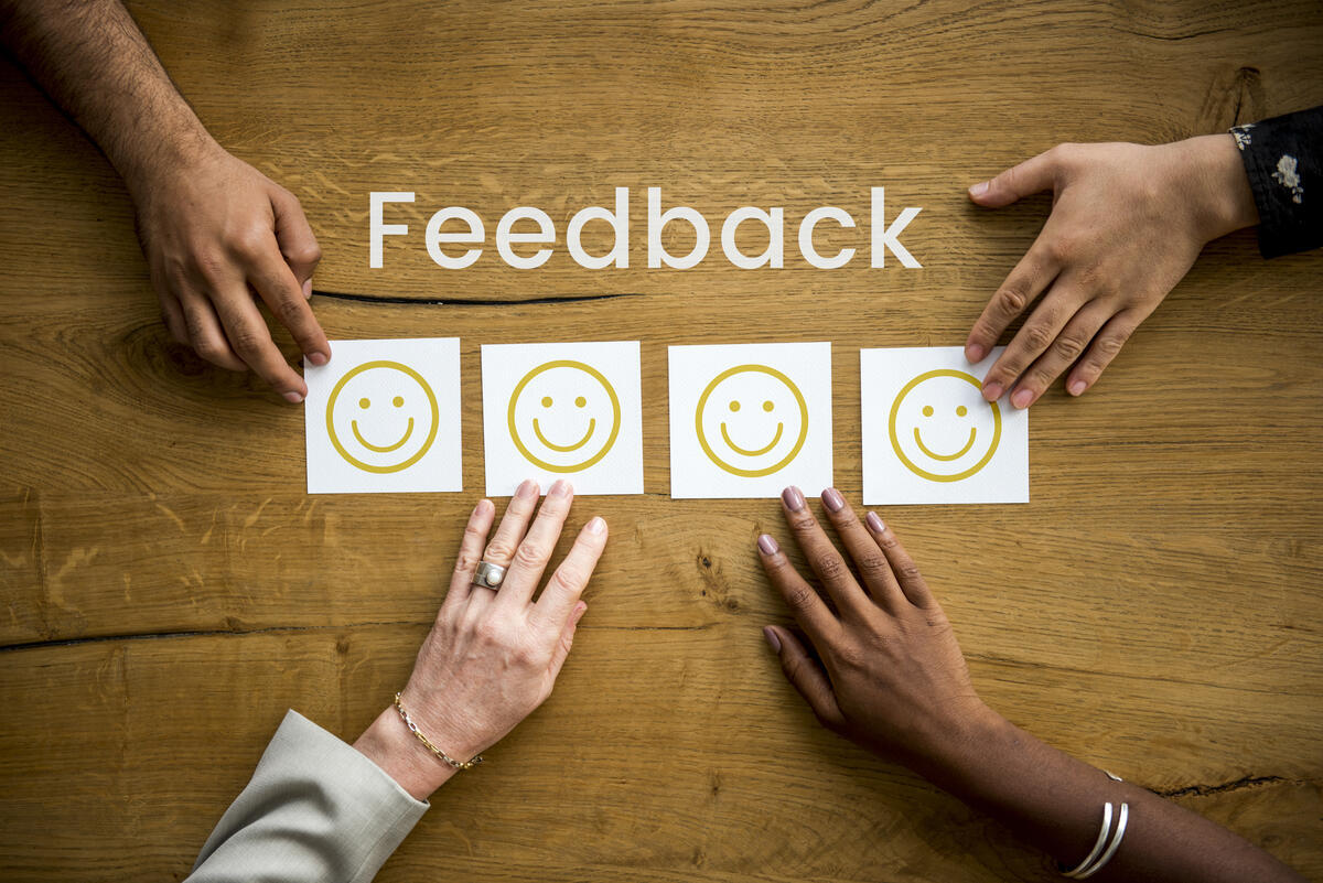 Feedback, Hände und Emojis auf Post-its