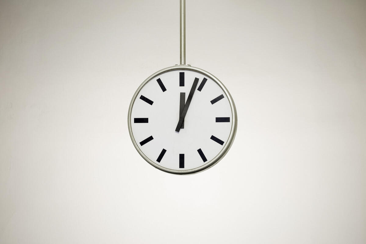 Wanduhr, die 4 nach zwölf zeigt.