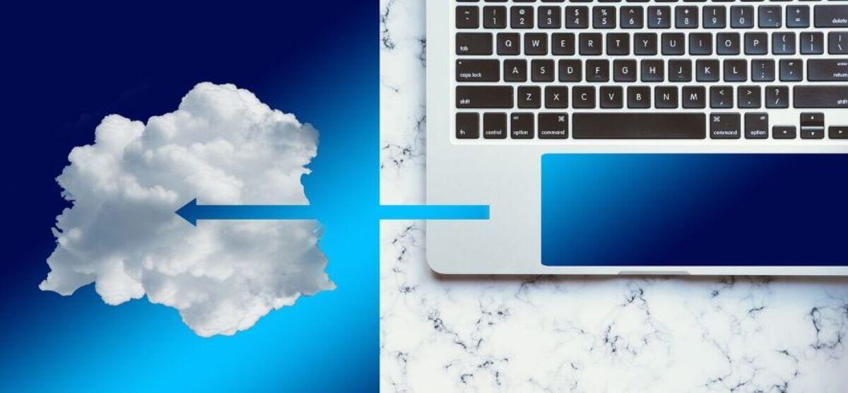 Laptop keyboard with arrow pointing to white cloud