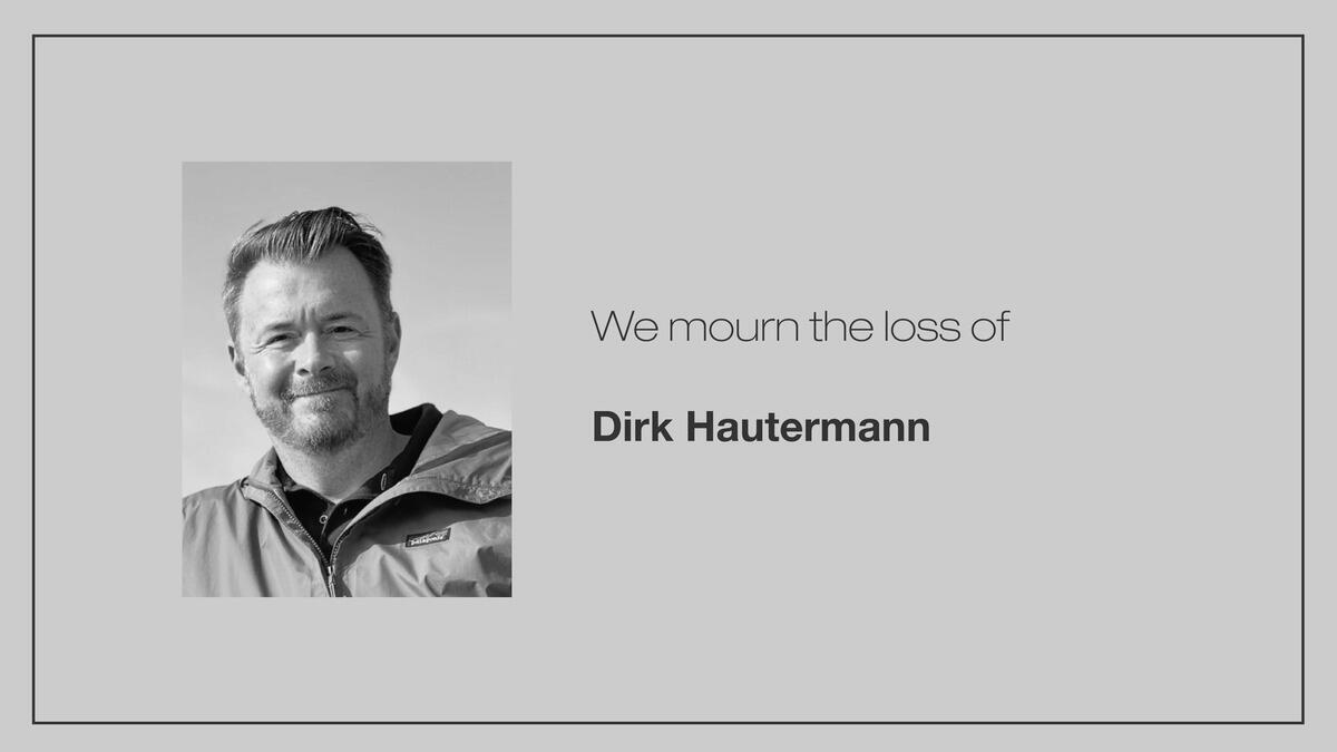 A gray background with a black-and-white photo of Dirk Hautermann, alongside the words “We mourn the loss of Dirk Hautermann”